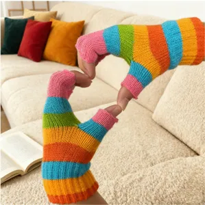Detailed view of colorful rainbow striped fingerless knit gloves showing cozy texture and design.