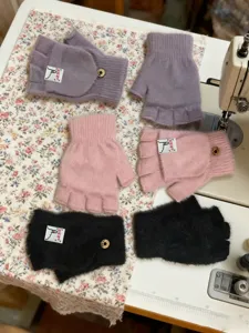 Detail view of fuzzy half-finger convertible winter gloves in purple, pink and black colors.