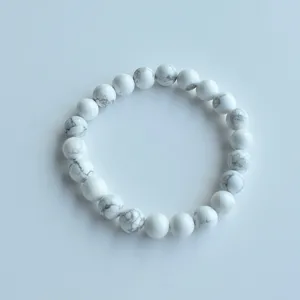 Close-up detail of natural white stone beaded elastic bracelet showing polished bead texture.