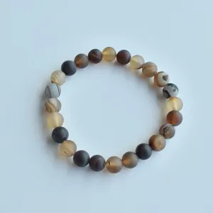 Close-up detail of natural stone beaded bracelet showing frosted texture and earthy tones.