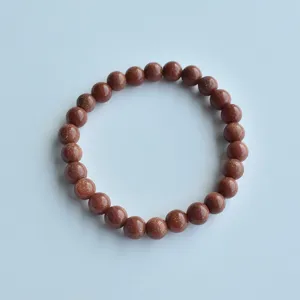 Brown goldstone beaded elastic bracelet detail shot, elegant shimmering stone jewelry.