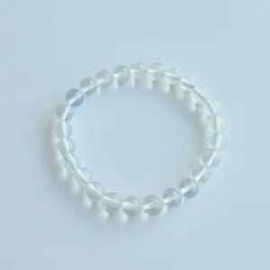 Close-up detail of clear crystal bead bracelet elastic string natural stone jewelry accessory.