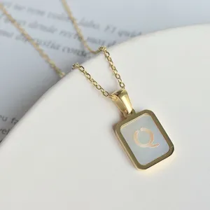 Detailansicht einer goldenen Titanstahl Halskette mit Perlmutt und Buchstaben Q Anhänger.