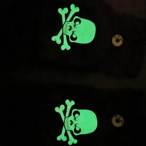 Winter warm half-finger gloves detail shot featuring luminous green skull and crossbones design.