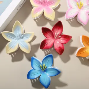 Gros plan sur des pinces à cheveux fleur de frangipanier aux couleurs dégradées