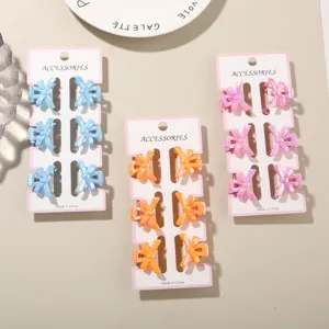 Close-up detail of 3cm iridescent mini bow hair claw clips in macaron colors on card