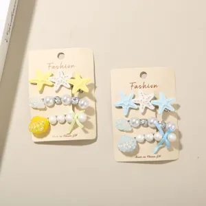 Detailansicht von Haarklammer-Sets mit Seestern- und Muschelmotiven auf Karten.