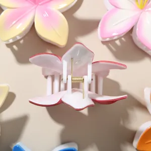 Vue détaillée d'une pince à cheveux fleur de frangipanier avec ressort en métal