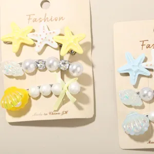 Detailansicht eines Haarspangen-Sets mit Seesternen, Perlen und schillernden Muscheln.