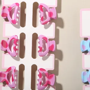 Detail view of 2.5cm mini pink and blue cow print hair claw clips in a 6-piece set