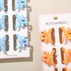 Close-up detail of 3cm mini bow hair claw clips in blue and orange macaron colors