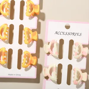Detailed view of 6-piece 2.5cm mini hair claw clips with colorful cow print designs