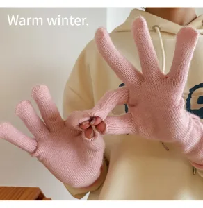Close-up detail of women's pink knit winter gloves, soft warm fabric for cold days.