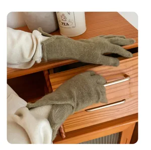 Close-up detail of women's warm knit gloves in solid olive green for cold autumn and winter.