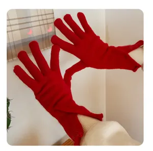 Red knit gloves detail shot showing finger separation and cozy winter wool material texture.