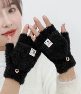 Detail view of black fluffy convertible fingerless winter gloves with cute label and button.