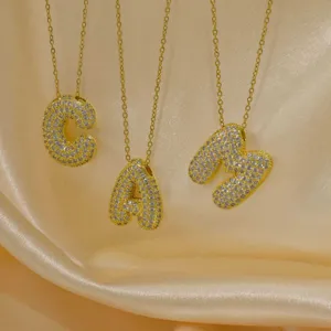 Nahaufnahme von klobigen goldenen Buchstaben C, A und M Anhänger Halsketten mit Strass.