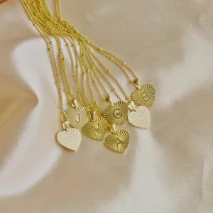 Close-up of gold sunburst heart initial necklace detail showing exquisite letter pendant craft.
