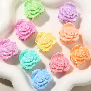 Primo piano di piccole mollette a forma di rosa perlata in vari colori pastello su un vassoio