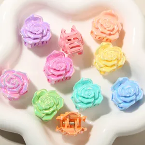 Dettaglio di piccole mollette per capelli a forma di rosa 3D in colori pastello