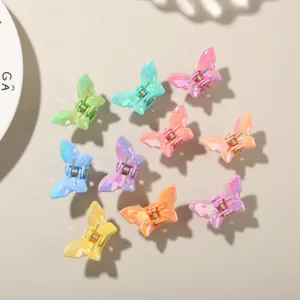 Dettaglio di nove mini mollette per capelli a farfalla in vari colori di caramelle lucide