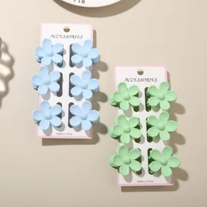 Set of 6 small matte flower hair clips in pastel blue and green for girls hair.