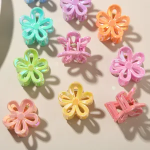 Primo piano di piccole mollette per capelli a forma di fiore in vari colori candy.