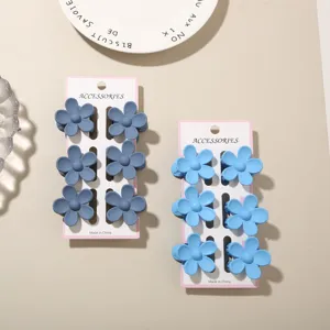 Detailed macro view of six-piece flower hair claw sets in navy and sky blue matte