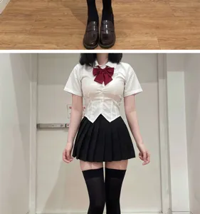 Detailaufnahme von schwarzen Overknee-Strümpfen kombiniert mit JK-Uniformrock und Loafern.