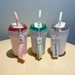 Three stylish insulated coffee tumblers with straws and woven CASNO straps on wood table