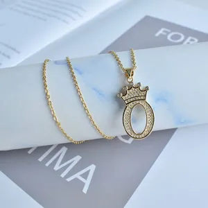 Gros plan détaillé du collier pendentif lettre O couronne étincelant de strass délicats.