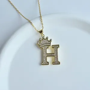 Collier pendentif lettre H couronne dorée avec zircons brillants scintillants vue de détail.