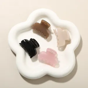 Set of four medium jelly color hair claws displayed on a decorative flower ceramic tray