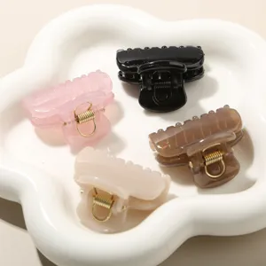 Detail shot of four medium PC hair claw clips in various jelly colors on a white plate.