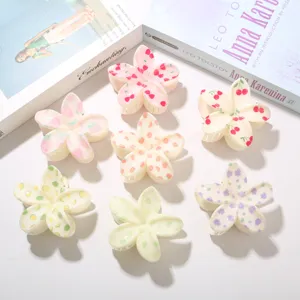 Detalle de varias pinzas para el cabello plumeria en tonos pastel con estampados de frutas.