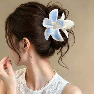 Vista detallada de una elegante pinza para el pelo con flores azules en un peinado moño