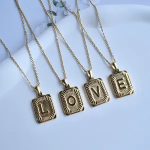 Close up of gold stainless steel square letter pendants spelling love necklace set detail