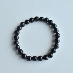 Detailed shot of a blue sandstone beaded elastic stretch bracelet, approx 8mm round beads.