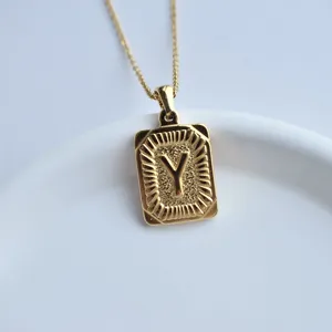 Detail close-up of gold stainless steel square letter Y pendant necklace with radiant texture.