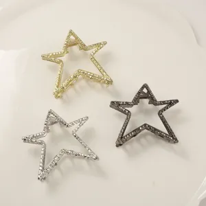 Detailed view of three metallic star-shaped hair claw clips with hammered texture
