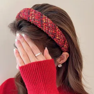 Primer plano de una diadema ancha de tweed rojo vintage en una modelo con estilo elegante.
