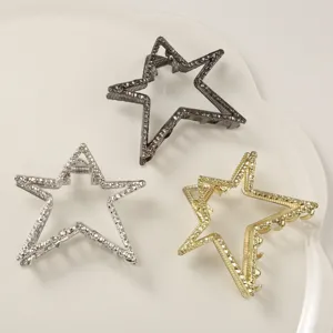 Detail view of three metallic star-shaped hair claw clips in silver, gold, and grey
