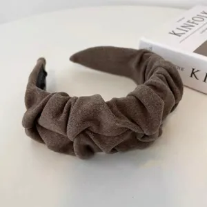 Detalle de primer plano de una diadema ancha plisada marrón vintage con textura de ante