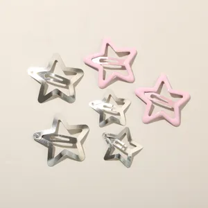 Dettaglio di sei fermagli per capelli a forma di stella in finiture rosa e argento metallizzato