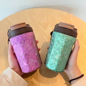 Detailansicht von lila und grünen Titan-Kaffeebechern mit glitzernder Textur
