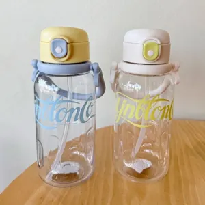 Primer plano de dos botellas de agua de plástico pastel en una mesa.