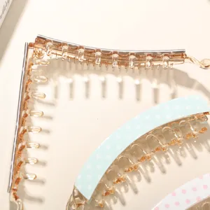 Detail view showing the sturdy internal teeth of a large polka dot acetate banana hair clip