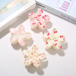 Cuatro pinzas para el cabello con forma de flor y estampados de cereza y fresa.