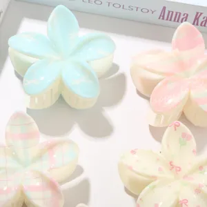 Detalle de pinzas para el cabello de flores Plumeria con bonitos estampados de lazos