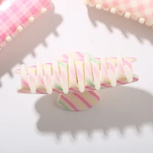 Gros plan détaillé montrant la pince à cheveux rayée de 10,5 cm en rose et vert pastel